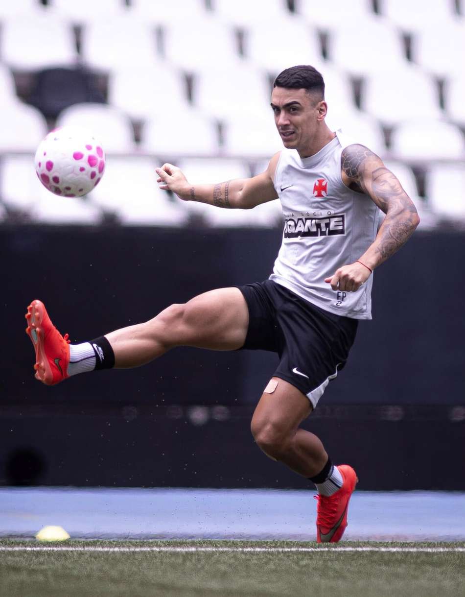 Puma em treino, uniforme cinza, chuteira vermelha, chutando a bola no ar.