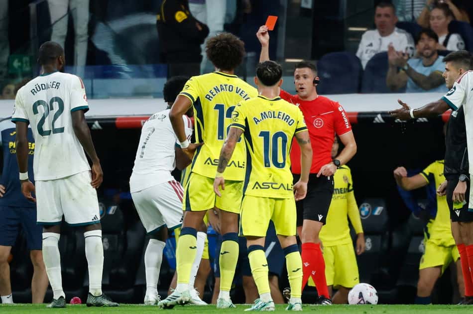 O árbitro Isidro Escuderos mostra o cartão vermelho para o atacante brasileiro do Real Madrid, número 7, Vinicius Junior (2º à esquerda), durante a partida do Campeonato Espanhol entre Real Madrid CF e Villarreal CF no Estádio Santiago Bernabéu, em Madri, em 10 de outubro de 2026. (Foto: Oscar Del Pozo / AFP)