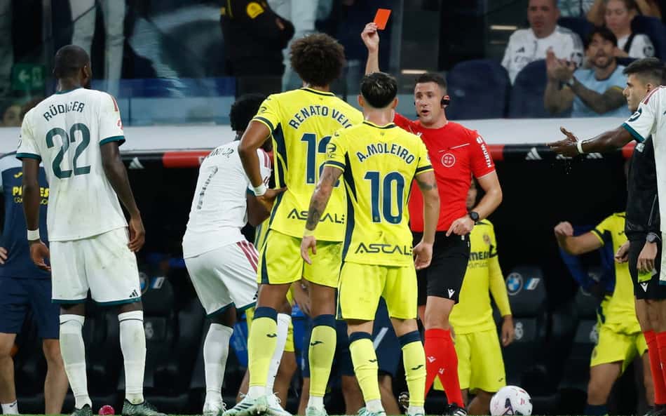 O árbitro Isidro Escuderos mostra o cartão vermelho para o atacante brasileiro do Real Madrid, número 7, Vinicius Junior (2º à esquerda), durante a partida do Campeonato Espanhol entre Real Madrid CF e Villarreal CF no Estádio Santiago Bernabéu, em Madri, em 10 de outubro de 2026. (Foto: Oscar Del Pozo / AFP)