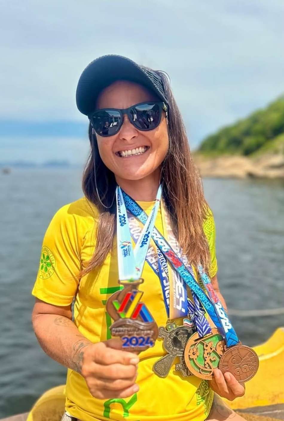 Atleta de canoagem va'a Rie Nagasako posa para foto com medalhas