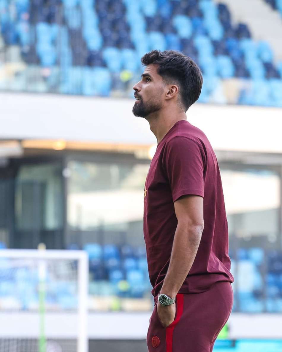 Com as mãos no bolso e camisa de treino, Rodrigão observa