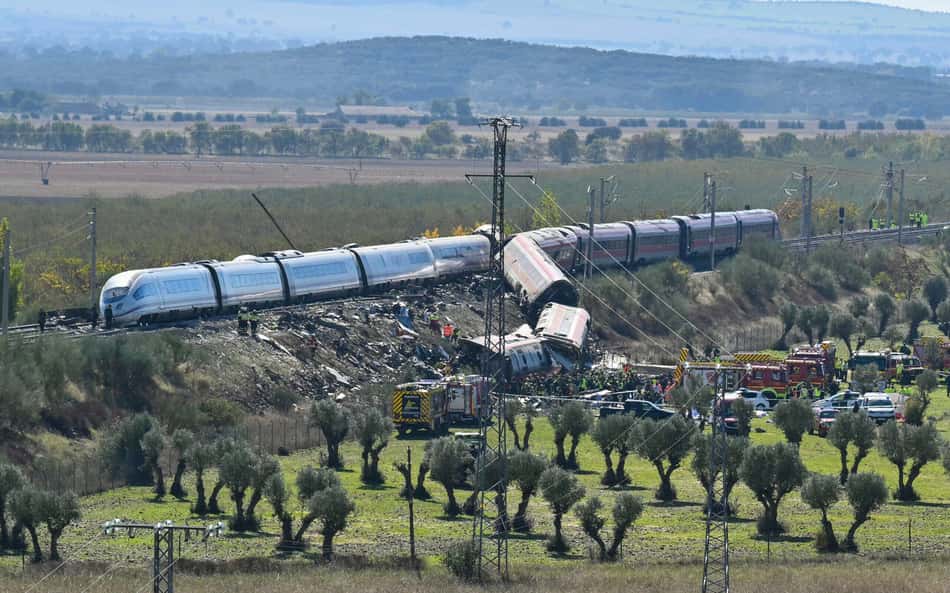 Trem descarrila em área rural: vagões tombados, equipes de resgate e bombeiros ao lado dos trilhos.