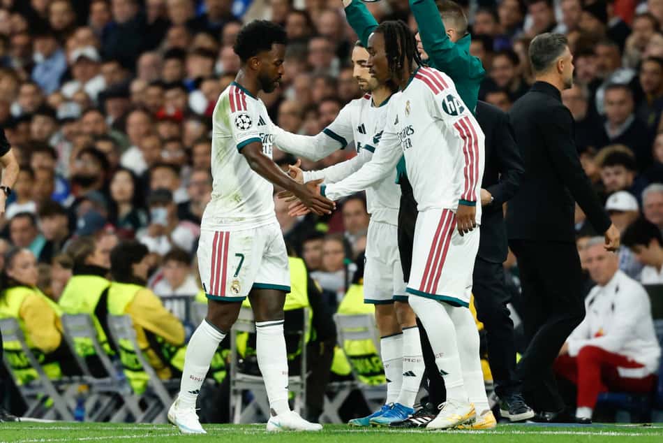 O atacante brasileiro do Real Madrid, número 7, Vinicius Junior (E), passa pelo técnico português do Real Madrid, José Mourinho, ao ser substituído durante a partida da 3ª rodada da Liga dos Campeões da UEFA entre Real Madrid CF e RB Leipzig, no estádio Santiago Bernabéu, em Madri, em 21 de outubro de 2026. (Foto: Oscar Del Pozo / AFP)