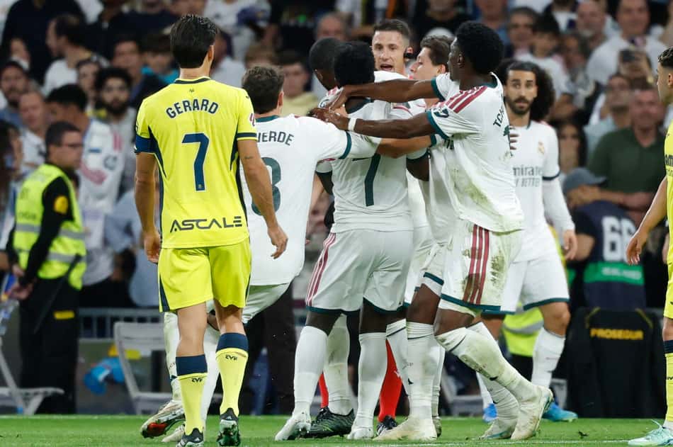 O atacante brasileiro do Real Madrid, número 07, Vinicius Junior (C), é contido por companheiros de equipe enquanto discute com o árbitro Isidro Escuderos após receber um cartão vermelho durante a partida do Campeonato Espanhol entre Real Madrid CF e Villarreal CF, no Estádio Santiago Bernabéu, em Madri, em 10 de outubro de 2026. (Foto: Oscar Del Pozo / AFP)