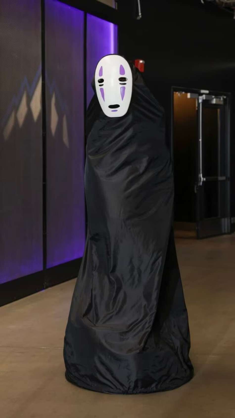 Victor Wembanyama fantasiado com máscara branca e capa preta em evento de Halloween.