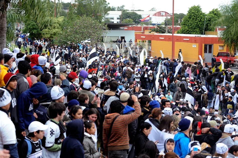 Torcida do Olimpia comemora na saída do aeroporto Silvio Pettirossi (Foto: Norberto Duarte/AFP)