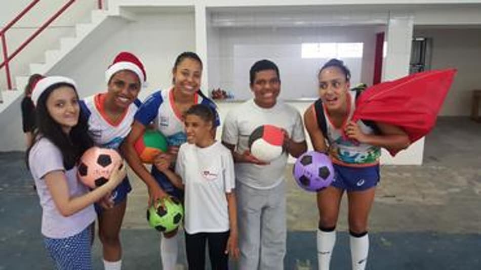 Atletas do Nestlé posam com crianças em ação social