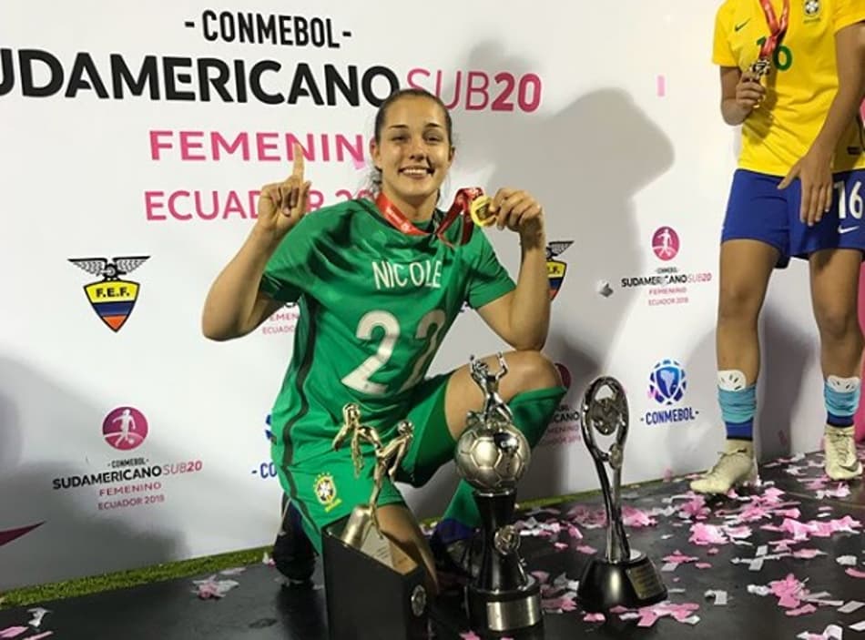 NICOLE - GOLEIRA<br>Defensora do Santos desde 2016, Nicole é a goleira mais jovem da Seleção Sub-20, com 17 anos. O início no futebol se deu a partir do irmão gêmeo, a quem a jovem, que acumula passagens pelo Juventus Jaraguá e Criciúma, acompanhava na escolinha. Instagram: @nicoleramos_12<br><br>