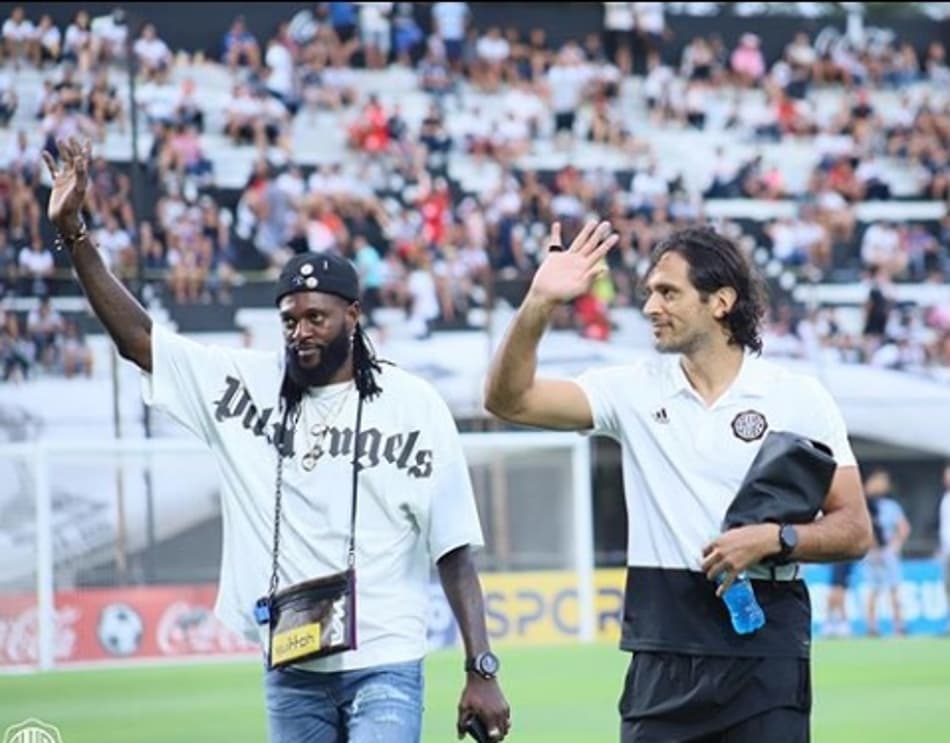 Emmanuel Adebayor assiste goleada do Olimpia e recebe o carinho da torcida
