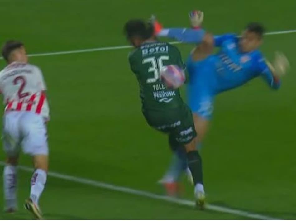 Acredite se quiser! Atacante recebe voadora do goleiro rival e VAR salva o árbitro