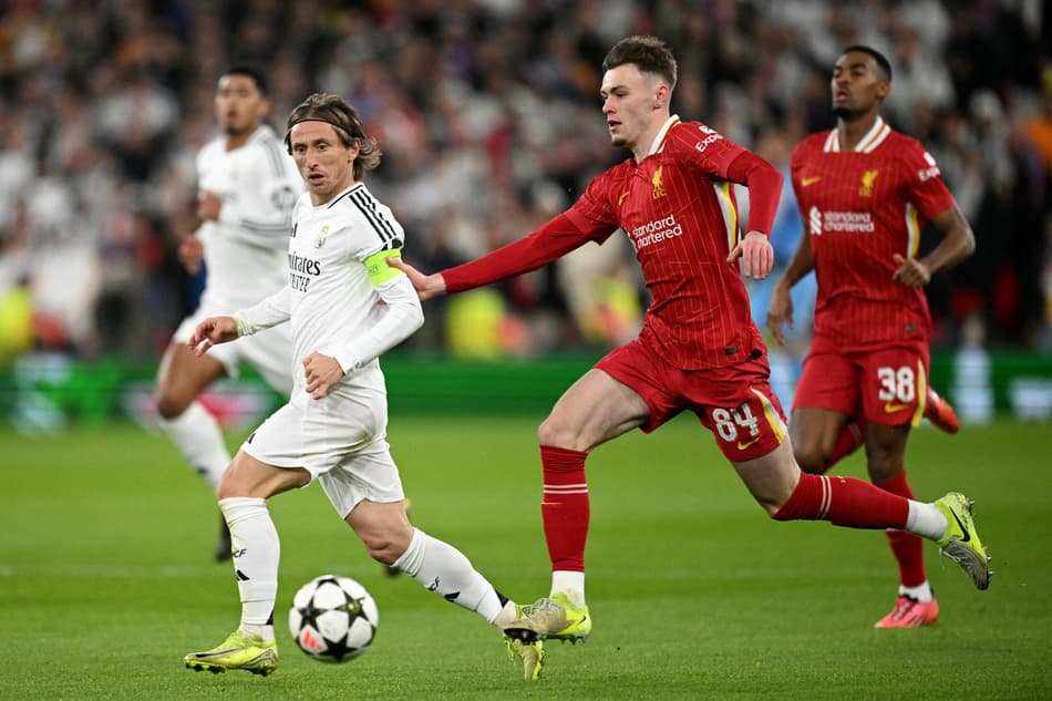 Conor Bradley, que entrou no lugar de Arnold, do Liverpool, e Luka Modric, do Real Madrid, disputam bola em jogo pela Champions League