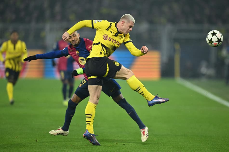 Raphinha e Julian Ryerson disputam a bola no jogo entre Borussia Dortmund e Barcelona pela Champions