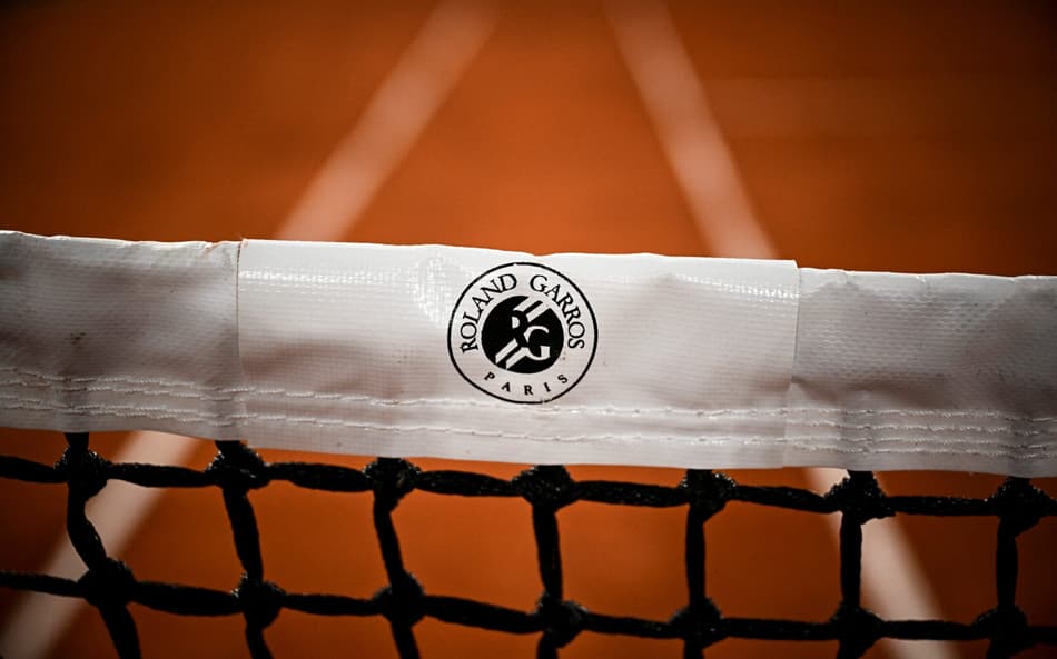 This photograph shows a logo for 'Roland Garros Paris' on the net across the Court Philippe-Chatrier ahead of the French Open 2025 tennis tournament at the Roland Garros Complex, in Paris on May 21, 2025. (Photo by JULIEN DE ROSA / AFP)