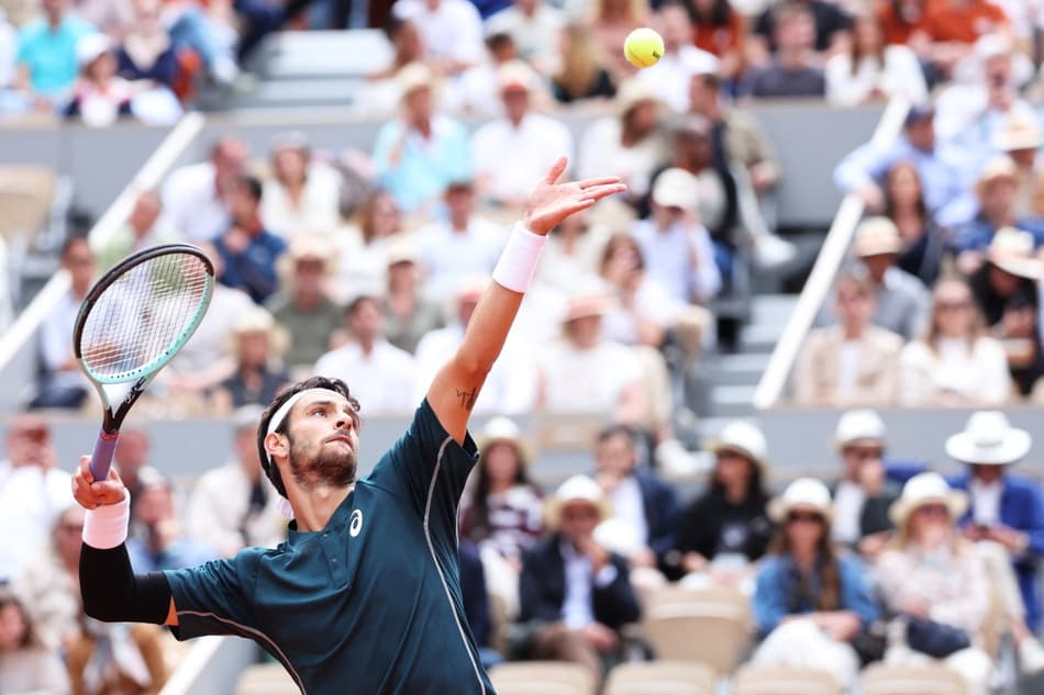 O italiano Lorenzo Musetti saca na partida contra o alemão Yannick Hanfmann em Roland Garros (Foto: ALAIN JOCARD / AFP)