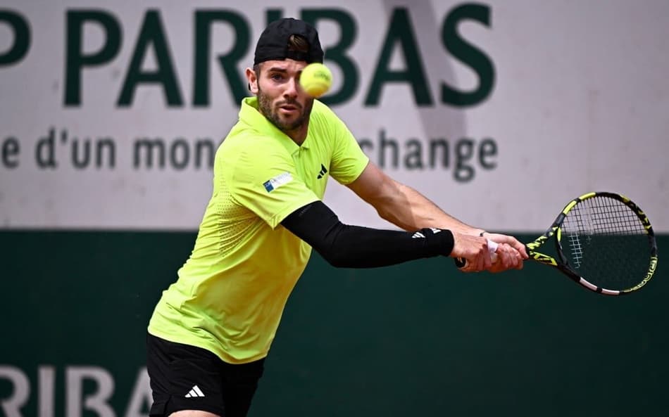O britânico Jacob Fearnley devolve a bola na vitória sobre o súço Stan Wawrinka (Foto: JULIEN DE ROSA / AFP)