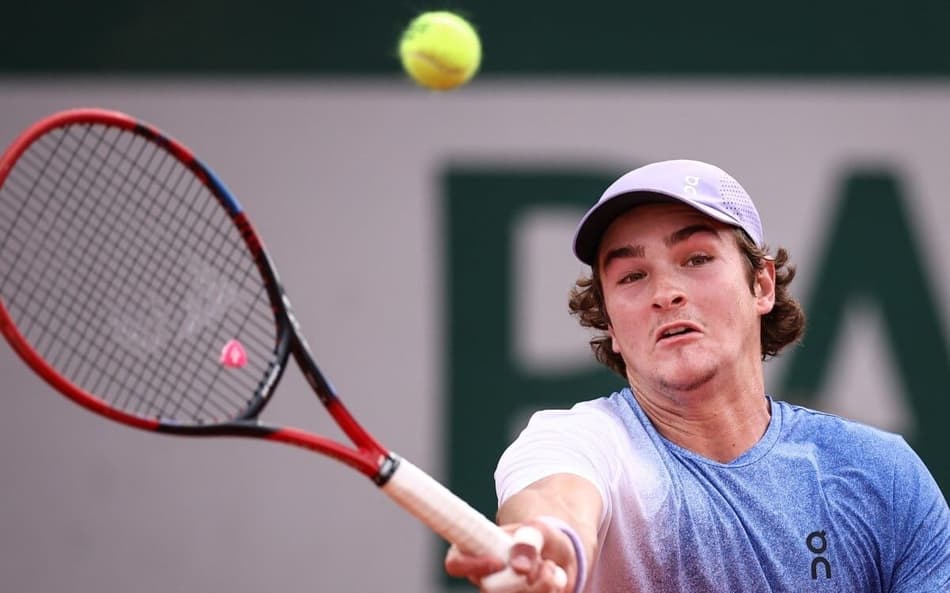 João Fonseca faz um voleio na partida contra o francês Pierre-Hugues Herbert em Roland Garros (Photo by Anne-Christine POUJOULAT / AFP)