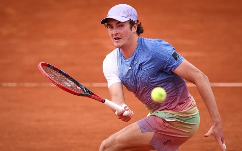 João Fonseca faz um voleio na partida contra o francês Pierre-Hugues Herbert em Roland Garros (Photo by Anne-Christine POUJOULAT / AFP)