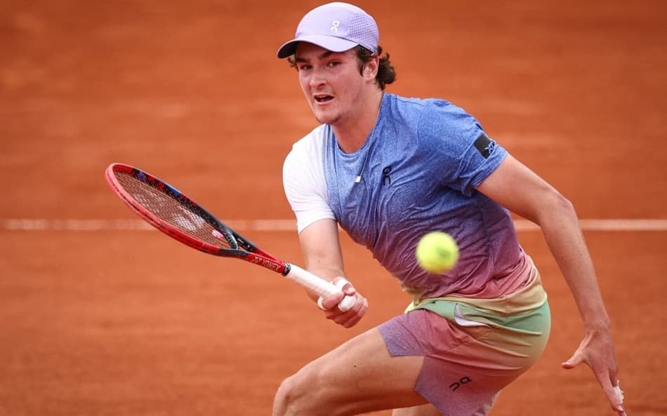 João Fonseca faz um voleio na partida contra o francês Pierre-Hugues Herbert em Roland Garros (Photo by Anne-Christine POUJOULAT / AFP)