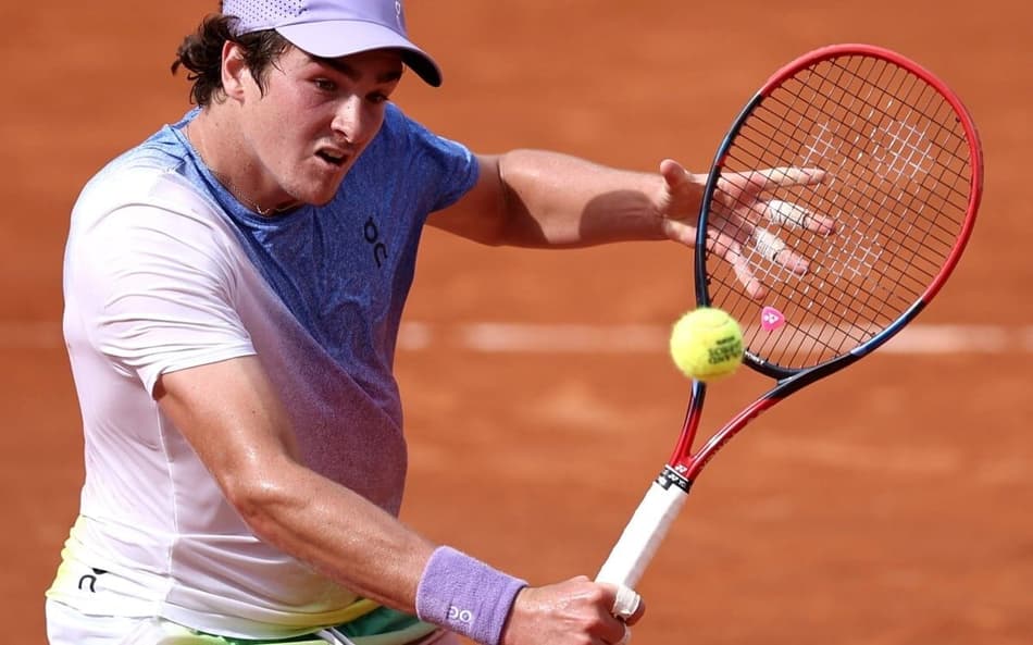 João Fonseca voleia na vitória sobre o francês Pierre-Hugues Herbert após a vitória em Roland Garros (FotoAnne-Christine POUJOULAT / AFP)