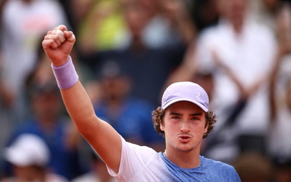 João Fonseca comemora a vitória sobre o francês Pierre-Hugues Herbert em Roland Garros (Foto: Anne-Christine POUJOULAT / AFP)
