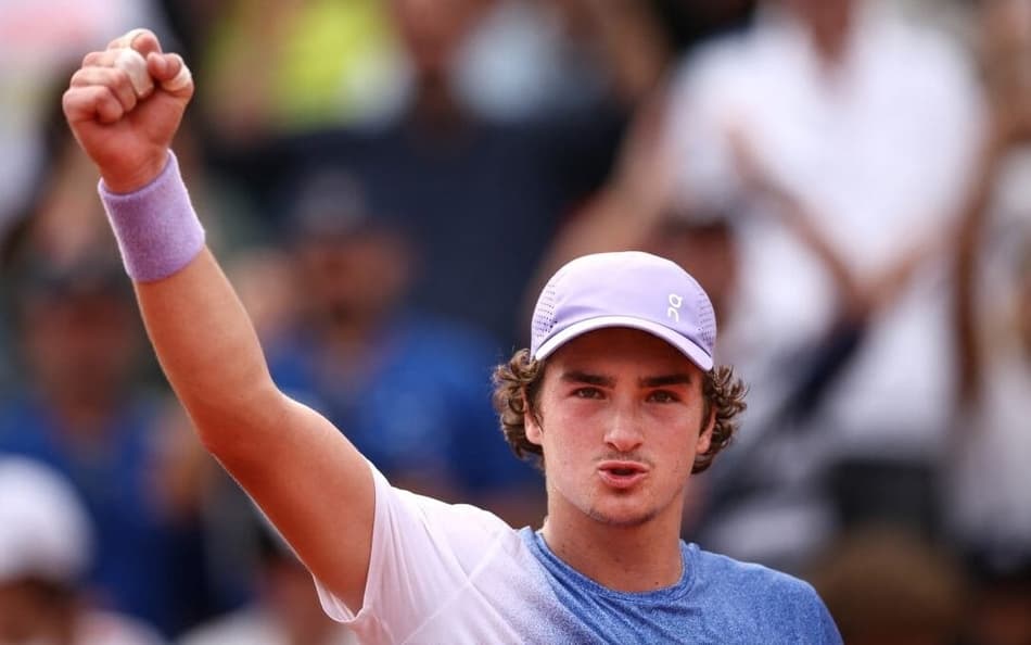 João Fonseca comemora a vitória sobre o francês Pierre-Hugues Herbert em Roland Garros (Foto: Anne-Christine POUJOULAT / AFP)
