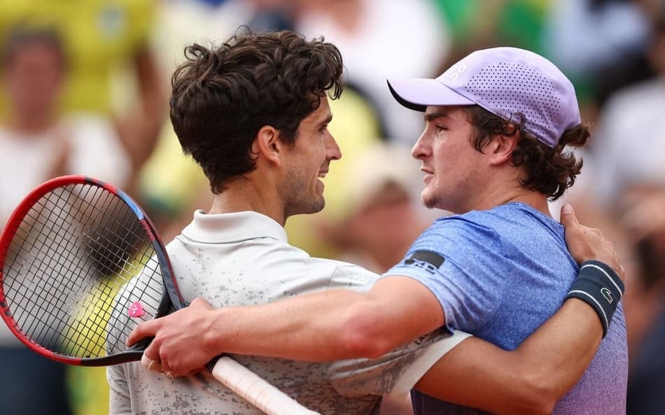 João Fonseca cumprimenta o francês Pierre-Hugues Herbert após a vitória em Roland Garros (FotoAnne-Christine POUJOULAT / AFP)