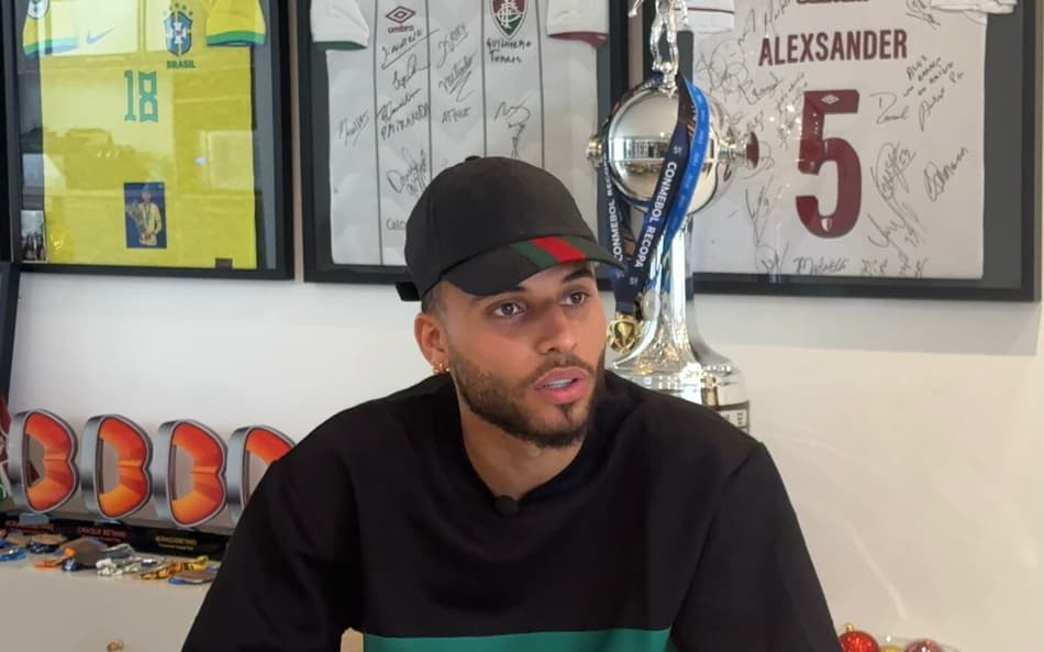 Ex-meia do Fluminense, Alexsander em entrevista ao Lance! com medalhas da Libertadores e Mundial ao fundo