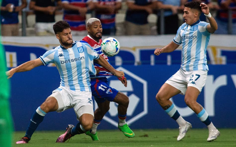 Marinho entre Marco Di Cesare e Gabriel Rojas em Fortaleza x Racing. (foto: Thiago Gadelha / AFP)