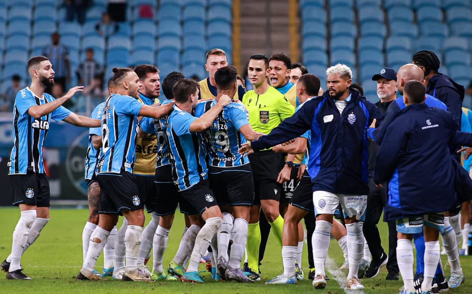Jogadores do Grêmio partem para cima do árbitro Matheus Candançan. (Foto: Maxi Franzoi/AGIF)