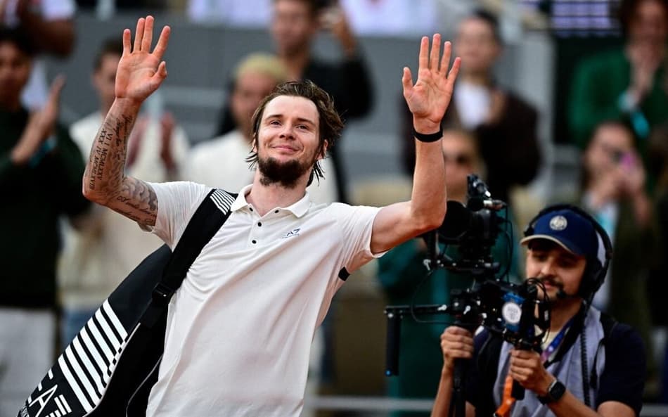 O cazaque Alexander Bublik se despede do público após a derrota para Jannik Sinner em Roland Garros (Foto: JULIEN DE ROSA / AFP)