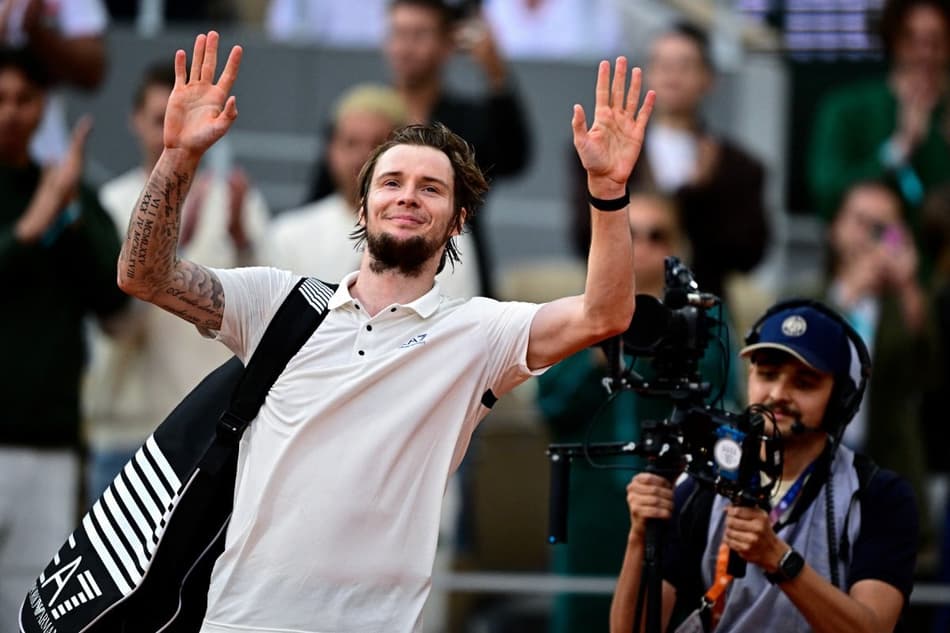 O cazaque Alexander Bublik se despede do público após a derrota para Jannik Sinner em Roland Garros (Foto: JULIEN DE ROSA / AFP)