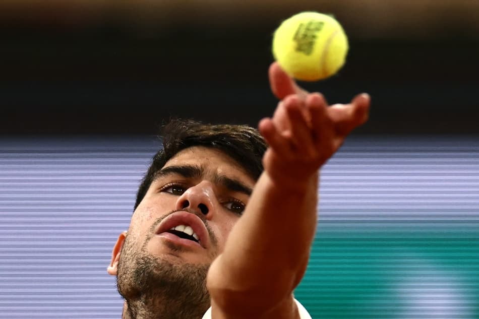 O espanhol Carlos Alcaraz saca na partida contra o italiano Lorenzo Musetti em Roland Garros (Foto: Thibaud MORITZ / AFP)
