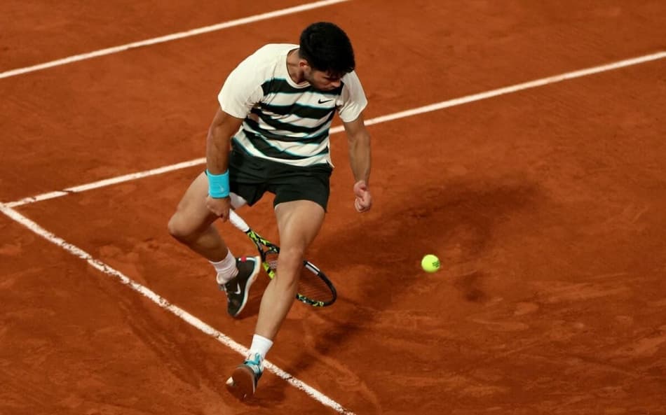 O espanhol Carlos Alcaraz faz uma grand-willy na partida contra o italiano Lorenzo Musetti em Roland Garros (Alain JOCARD / AFP)