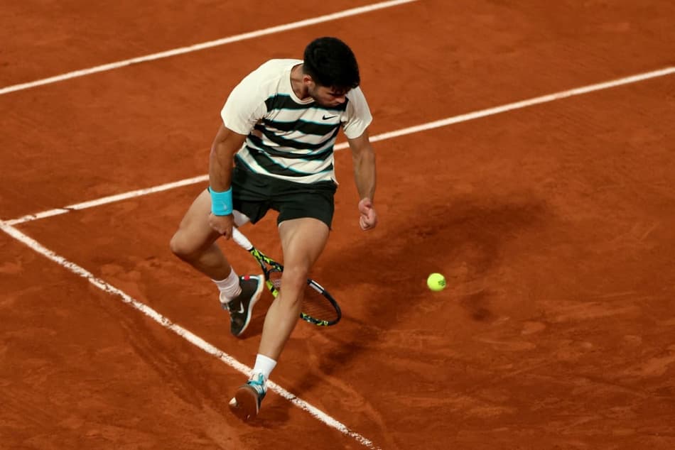 O espanhol Carlos Alcaraz faz uma grand-willy na partida contra o italiano Lorenzo Musetti em Roland Garros (Alain JOCARD / AFP)