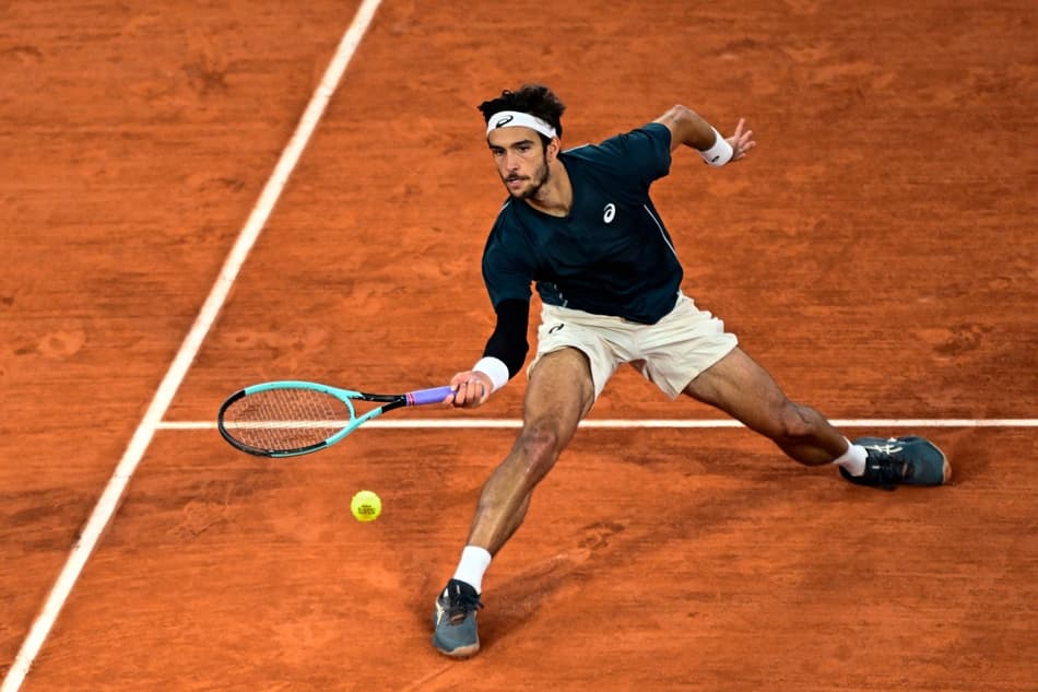 O italiano Lorenzo Musetti devolve a bola contra o espanhol Carlos Alcaraz em Roland Garros (Foto: JULIEN DE ROSA / AFP)