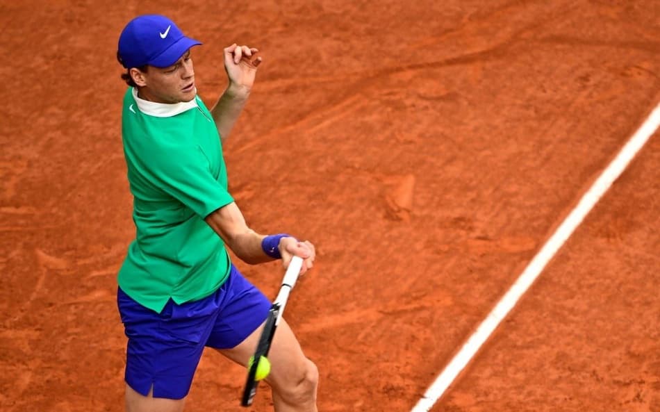 O italiano Jannik Sinner devolve a bola na partida contra o sérvio Novak Djokovic (Foto: JULIEN DE ROSA / AFP)