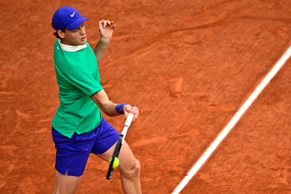 O italiano Jannik Sinner devolve a bola na partida contra o sérvio Novak Djokovic (Foto: JULIEN DE ROSA / AFP)