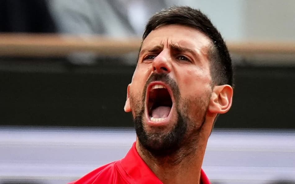 O sérvio Novak Djokovic solta o grito na semifinal de Roland Garros contra o italiano Jannik Sinner (Foto: Dimitar DILKOFF / AFP)