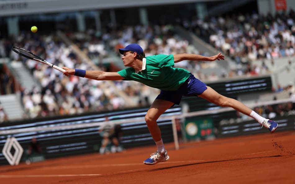 O italianoJannik Sinner se estica para devolver a bola para o espanhol Carlos Alcaraz na final de Roland Garros (Foto: Alain JOCARD / AFP)