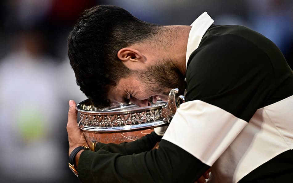 O espanhol Carlos Alcaraz segura o troféu de Roland Garros (Foto: JULIEN DE ROSA / AFP)