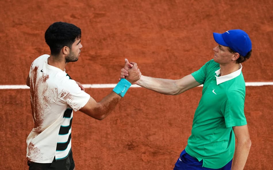 O espanhol Carlos Alcaraz e o italiano Jannik Sinner se cumprimentam após a épica final de Roland Garros (Foto: Dimitar DILKOFF / AFP)
