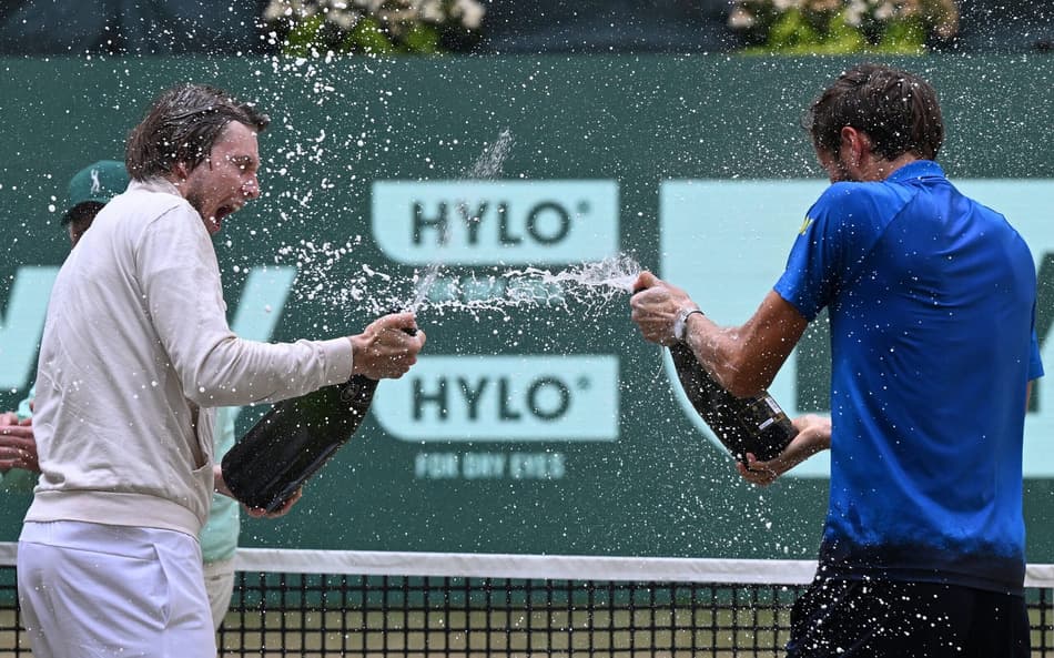 O cazaque Alexander Bublik (e) e o russo Daniil Medvedev celebram com champanhe após a final do ATP de Halle (Foto: CARMEN JASPERSEN / AFP)