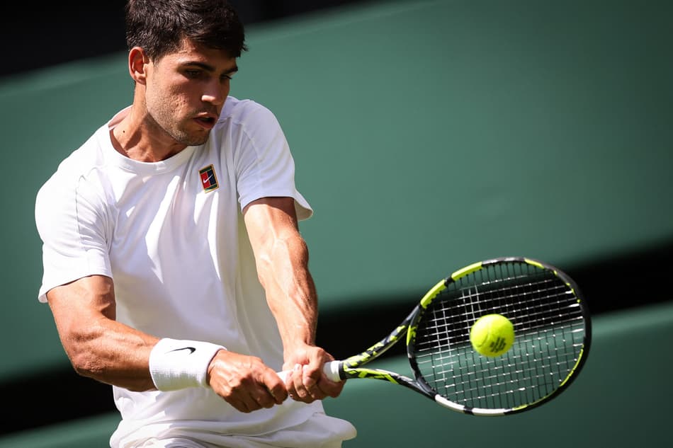 O bicampeão espanhol Carlos Alcaraz acerta o backhand contra o italiano Fabio Fognini (Foto: HENRY NICHOLLS / AFP)