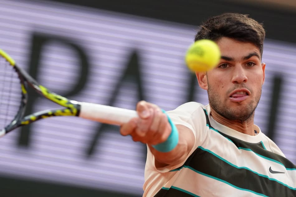 Carlos Alcaraz dá um forehand contra Tommy Paul em Roland Garros (foto: Dimitar DILKOFF / AFP)