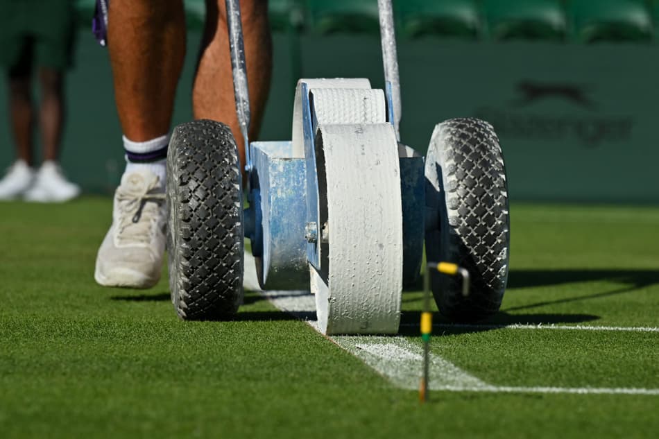 Linhas de uma quadra sendip pintadas no primeiro dia de Wimbledon (foto: Glyn KIRK / AFP)
