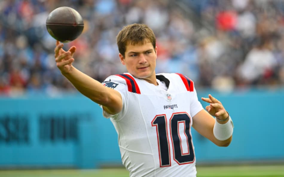 Drake Maye, Quarterback dos Patriots, lançando uma bola de futebol americano na NFL, sem capacete