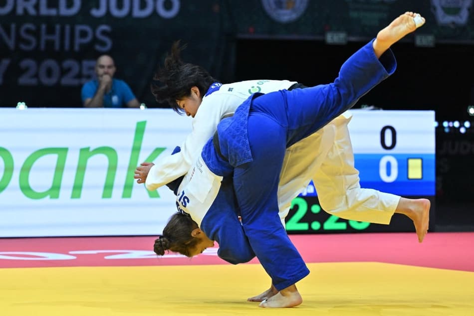A japonesa Shiho Tanaka enfrenta Kaja Schuster (azul), da Eslovênia, nas eliminatórias femininas (Photo by Attila KISBENEDEK / AFP)