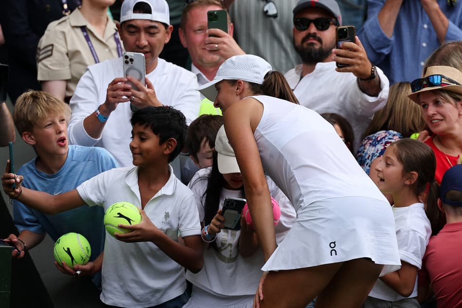 A polonesa Iga Swiatek posa com torcedores após nova vitória em Wimbledon (Foto: Adrian Dennis / AFP)
