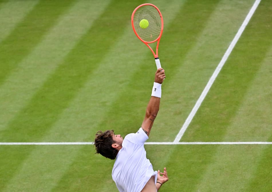 O italaino Flavio Cobolli saca na partida contra o croata Marin Cilic (Foto: Glyn KIRK / AFP)