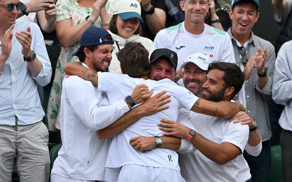O italiano Flavio Cobolli é abraçado pelo pai, Stefano, e por sua equipe após vitória sobre o croata Marin Cilic (Foto: Glyn KIRK / AFP)